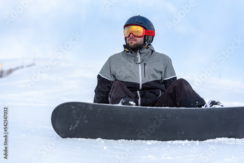 Young man snowboarding on the slopes of a ski resort