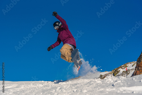 Young woman snowboarder in motion on snowboard in mountains