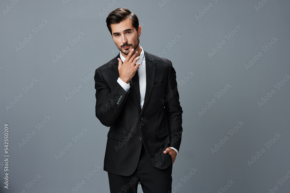 Man confident businessman in a stylish suit with jacket tie and white shirt on a gray background portrait. The concept of young businesses and startups Man confident businessman in a stylish suit with jacket tie and white shirt on a gray background portrait. The concept of young businesses and startups