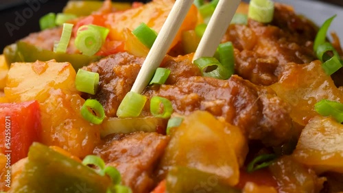 Eating Sweet and sour pork with chopstick