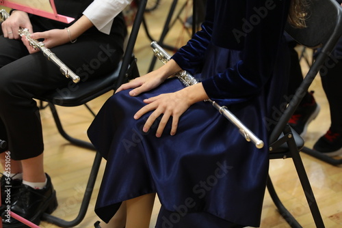 Girl flutist sitting with a musical instrument on her knees