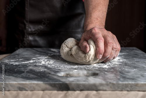 Fototapeta Naklejka Na Ścianę i Meble -  Man preparing pizza, dough on marble table.