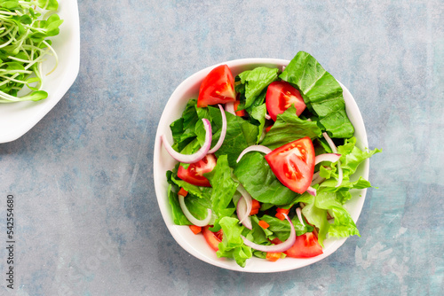 Healthy food leave lettuce vegetable salad has tomato in bowl on blue wood background.