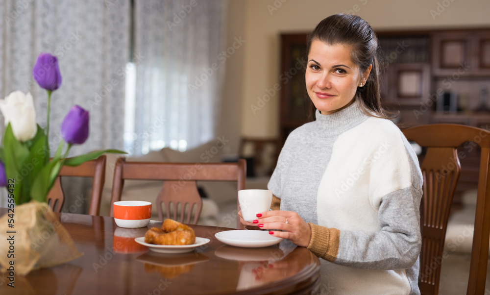 Portrait of elegant woman is posing with tea at home. High quality photo