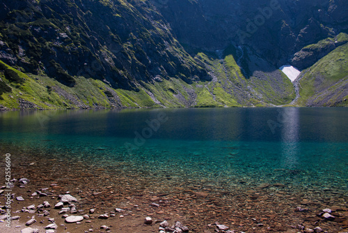 Azure water of Czarny Staw pod Rysamy or Black Pond lake near the Morskie Oko Mountain Hut in Polish Tatry mountains, Zakopane, Poland