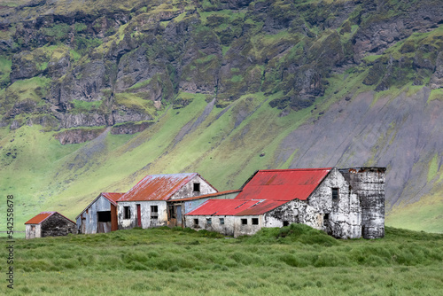 Abandoned Icelandic farm in the Spring, with mountain range in background