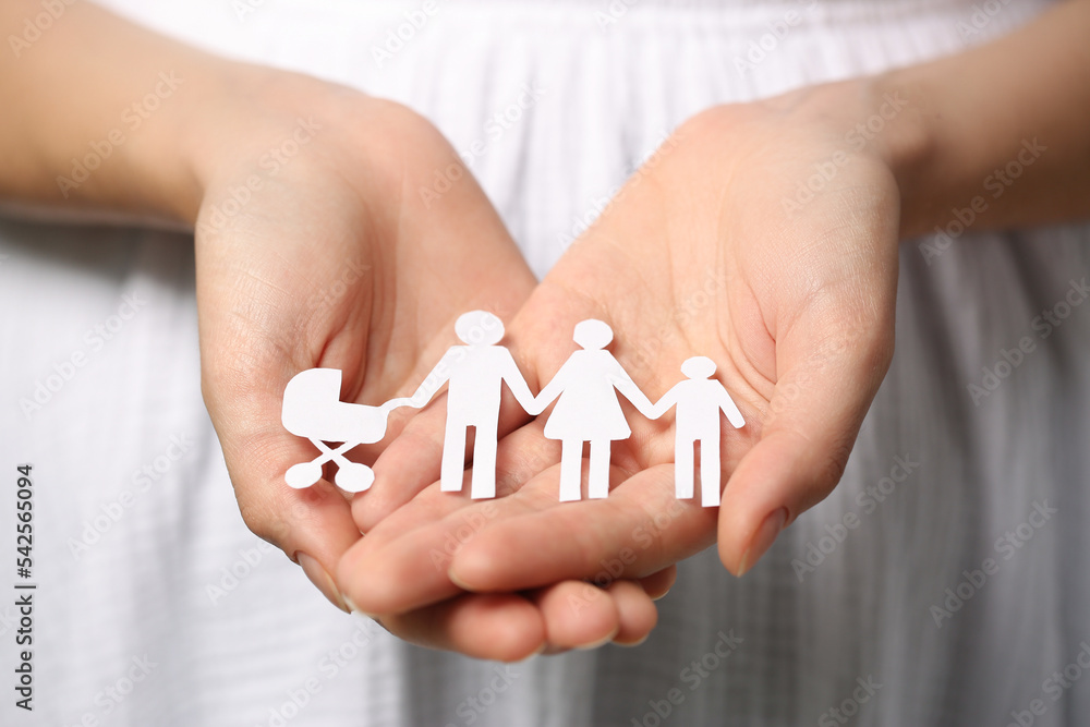 Woman holding paper family figures, closeup. Insurance concept Woman holding paper family figures, closeup. Insurance concept