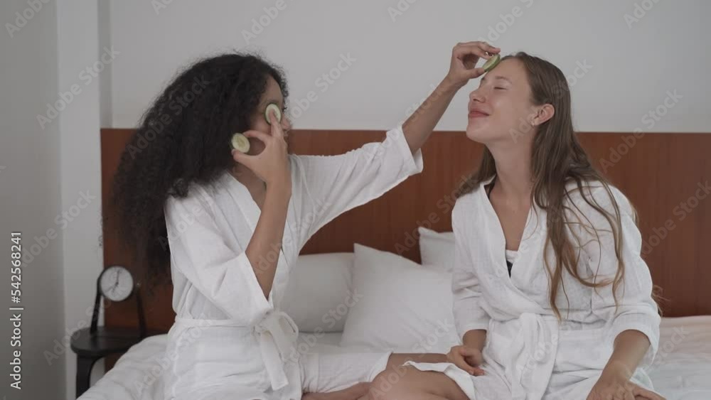 Portrait of two young multiracial women sitting on the bed feeling happy during facial skin
Portrait of two young multiracial women sitting on the bed feeling happy during facial skin