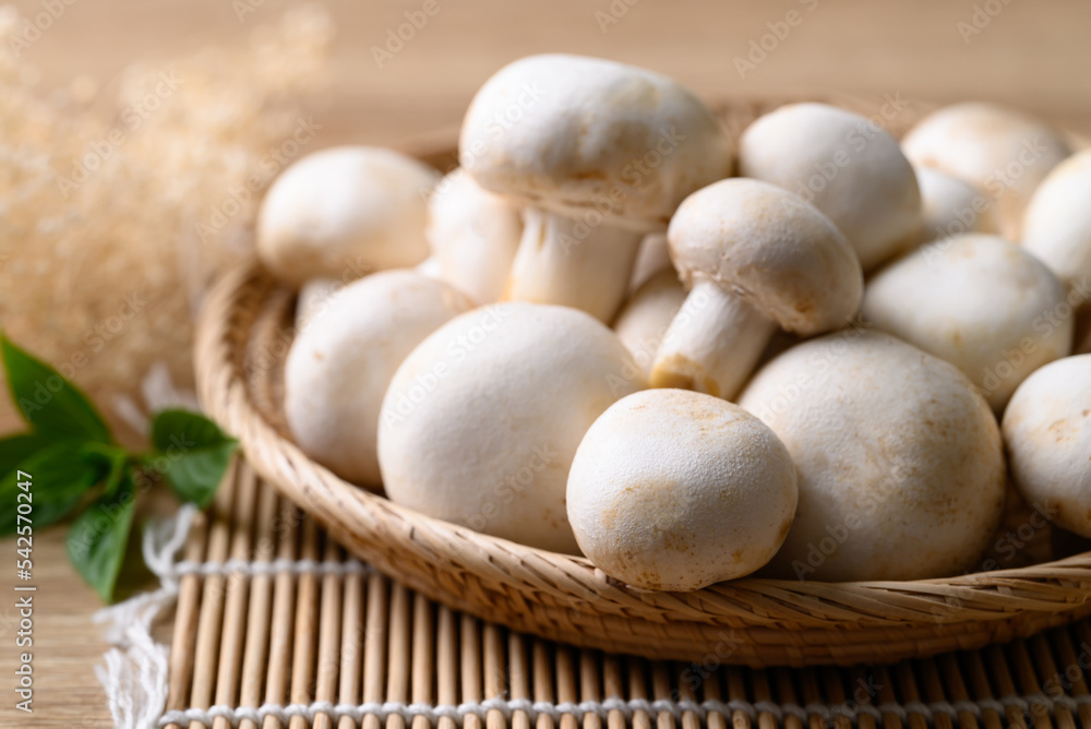 Fresh white champignon mushroom in basket on wooden background Fresh white champignon mushroom in basket on wooden background