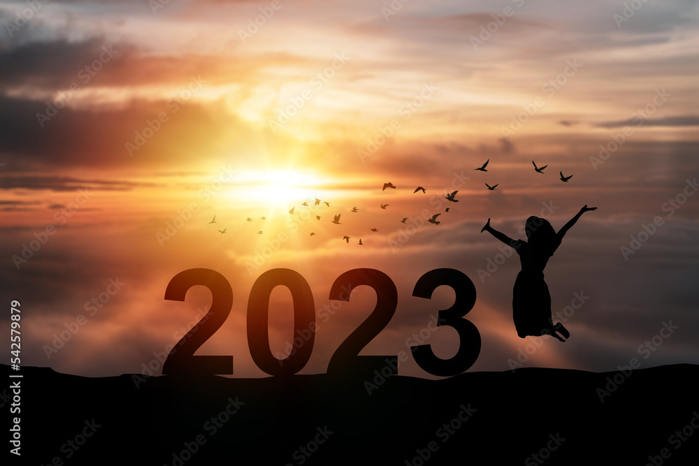 Young woman enjoying and celebrating New Year 2023 with the beautiful sunrise sky and clouds Young woman enjoying and celebrating New Year 2023 with the beautiful sunrise sky and clouds