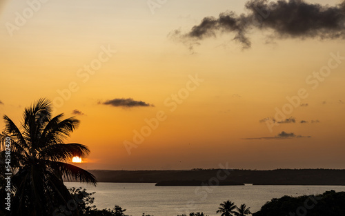 Sunset on a heavenly beach. Silhouette of palm trees is silhouetted