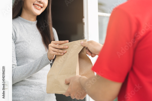 Canvas Print Postman, service fast food asian young woman, girl hand received order, delivery man, male holding, carrying paper bag send to customer house