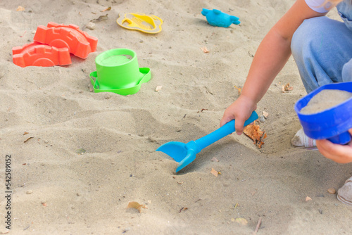 little girl having fun on playground in sandpit. Toddler playing with sand molds and making mudpies. Outdoor creative activities for kids