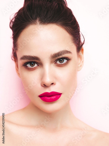 Fashion beauty portrait of young brunette woman with evening stylish  makeup and perfect clean skin. Sexy model with hair in a bun posing in studio. With pink bright natural lips. Isolated on white
