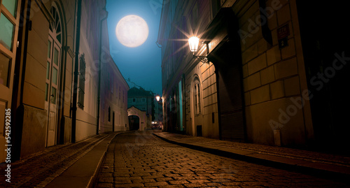 Photography old night street of Prague and the full moon in the night sky
