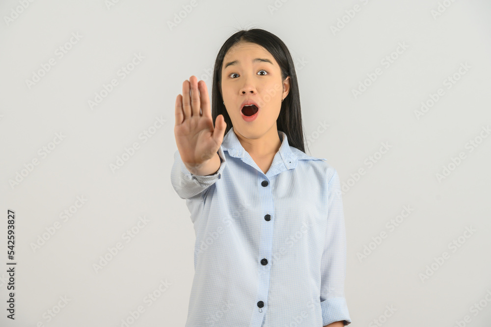 Portrait of Excited young asian woman in blue shirt showing hand foreground and looking at camera isolated on white background Portrait of Excited young asian woman in blue shirt showing hand foreground and looking at camera isolated on white background