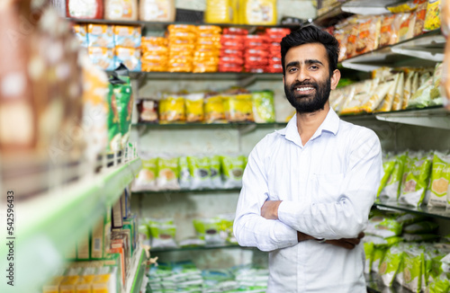 portrait of  smiling indian male in grocery with pointing toward the product  © Photographielove