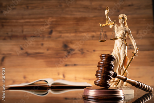 Law symbols composition. Law and justice concept.  Themis sculpture and judge’s gavel on wooden background.