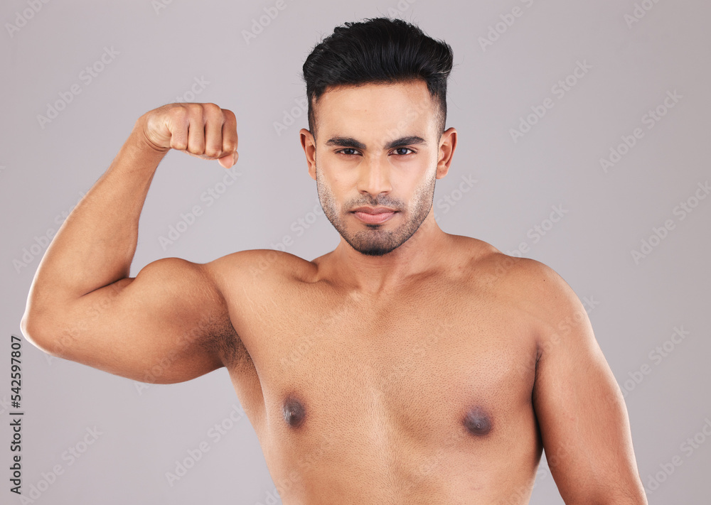 Fitness, portrait and man flexing his bicep for motivation, energy and power in a studio. Wellness, health and athlete from Mexico with strong arm muscles after training isolated by a gray background Fitness, portrait and man flexing his bicep for motivation, energy and power in a studio. Wellness, health and athlete from Mexico with strong arm muscles after training isolated by a gray background