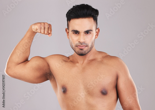 Fitness, portrait and man flexing his bicep for motivation, energy and power in a studio. Wellness, health and athlete from Mexico with strong arm muscles after training isolated by a gray background