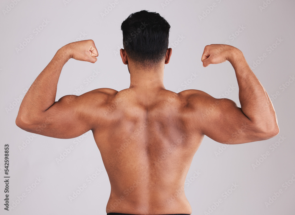 Foto Stock Fitness, back muscle flexing and man isolated on gray studio  background. Wellness, sports and body builder showing off biceps during  training, workout or exercise for body strength, energy or power.