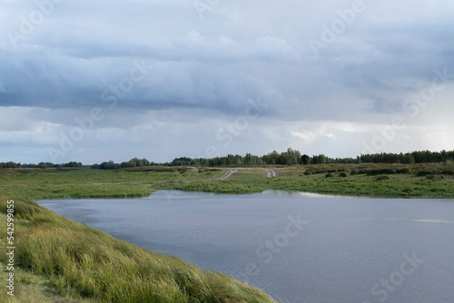 Beautiful natural landscape of a forest lake and blue sky with clouds.