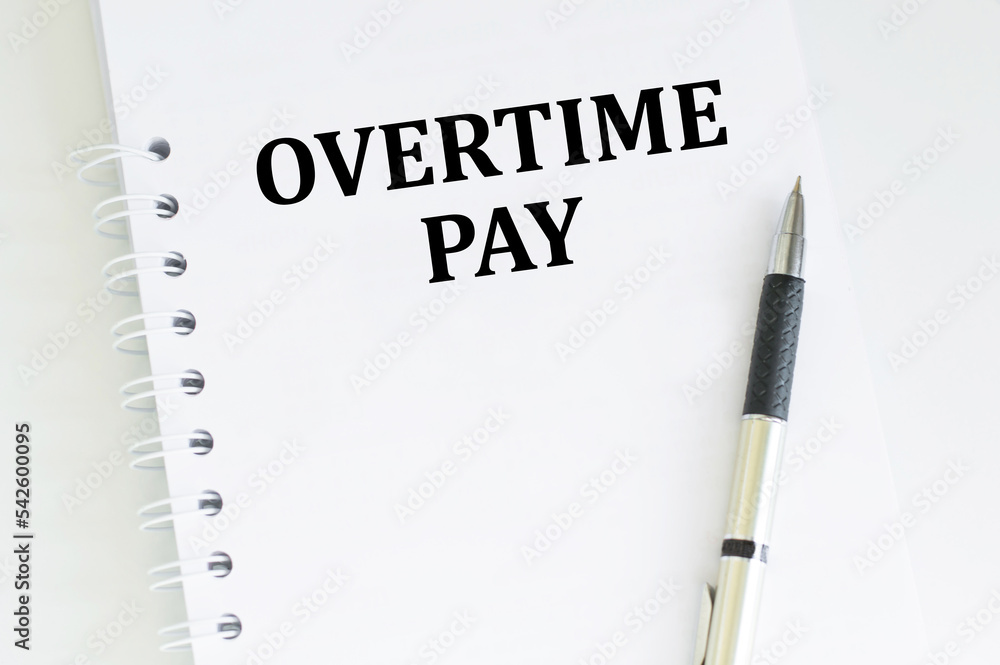 Financial concept about OVERTIME PAY with sign on the sheet. Financial concept about OVERTIME PAY with sign on the sheet.