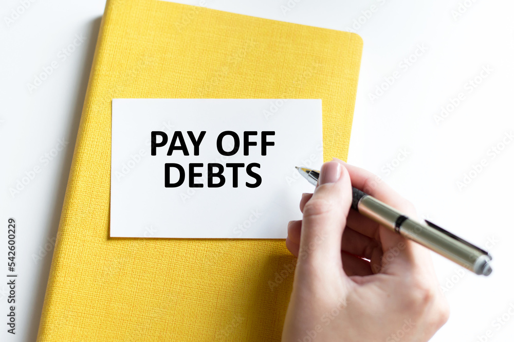 Work smarter text Pay Off Debts on white sheet with pen and tables. Work smarter text Pay Off Debts on white sheet with pen and tables.