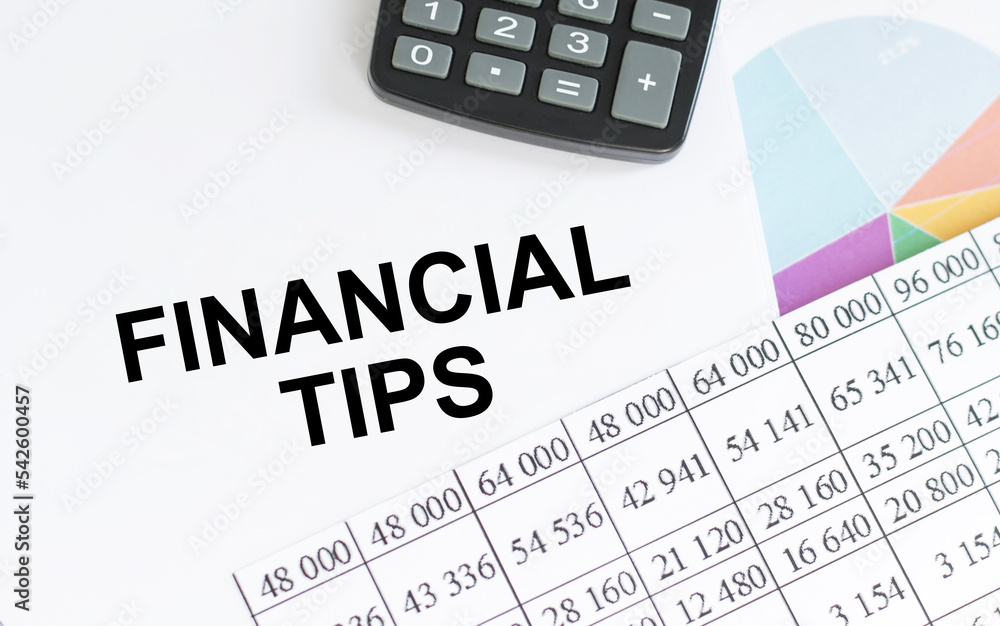 FINANCIAL TIPS . Text written on notepad with office tools and documents. FINANCIAL TIPS . Text written on notepad with office tools and documents.
