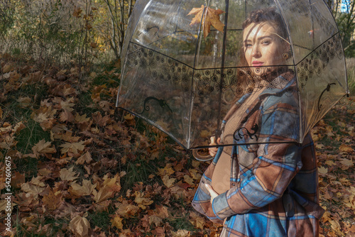 A happy young pregnant woman with an umbrella is waiting for her baby