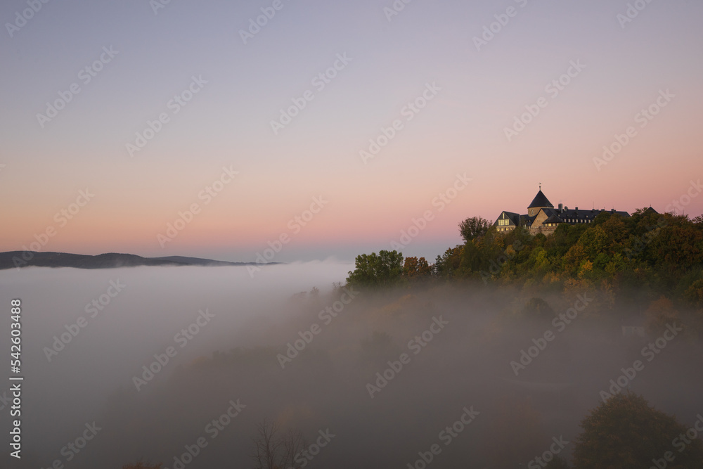 View to german palais called Waldeck in the morning with fog over the lake Edersee