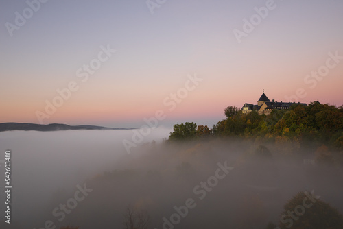 View to german palais called Waldeck in the morning with fog over the lake Edersee