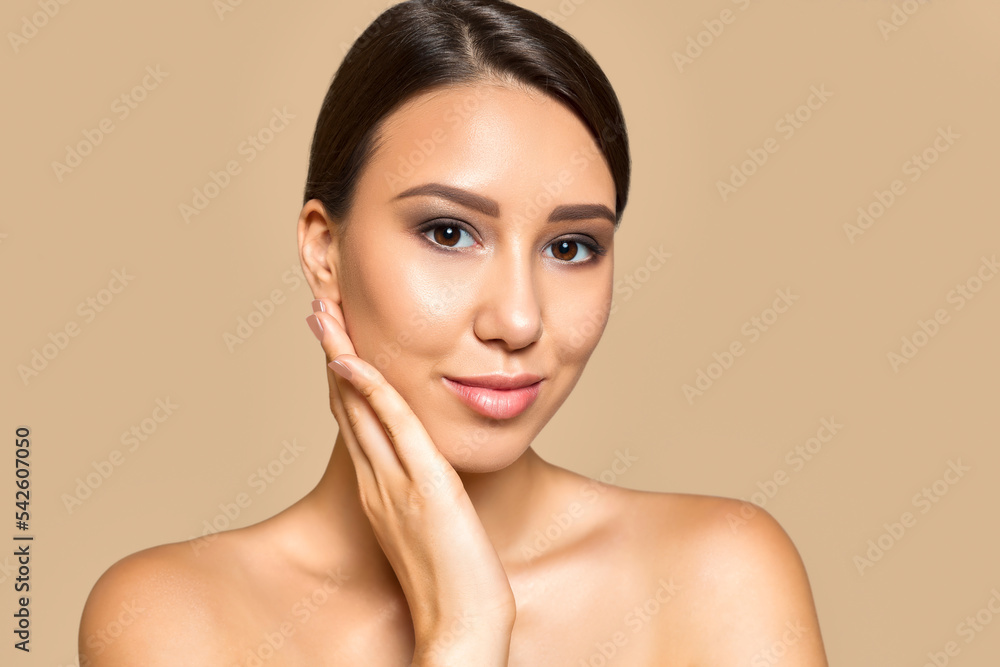 Skincare concept. Beauty portrait of young woman with clean healthy skin and natural make up posing against beige background. Skincare concept. Beauty portrait of young woman with clean healthy skin and natural make up posing against beige background.