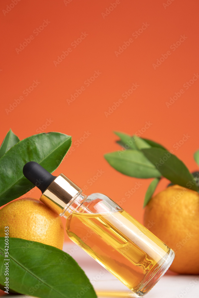 Natural organic orange essential oil for skin face and body health care. Moisturizing, aromatherapy, detox treatment, anti-stress effect. Fresh fruit, green leaves, orange background Natural organic orange essential oil for skin face and body health care. Moisturizing, aromatherapy, detox treatment, anti-stress effect. Fresh fruit, green leaves, orange background