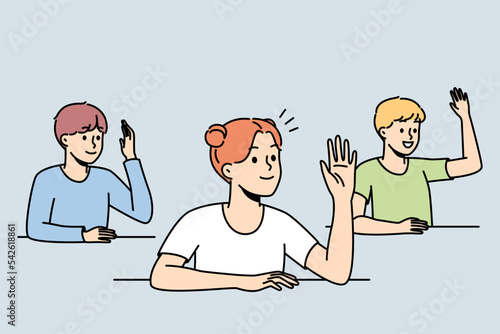 Smiling kids sit at desks at school raise hands asking or answering questions. Happy children engaged in activity in classroom. Vector illustration. 