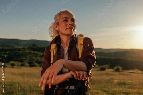 Smiling woman is taking a break from hiking photo