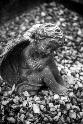 closeup of stoned angel sitting on tomb at the cemetery © pixarno