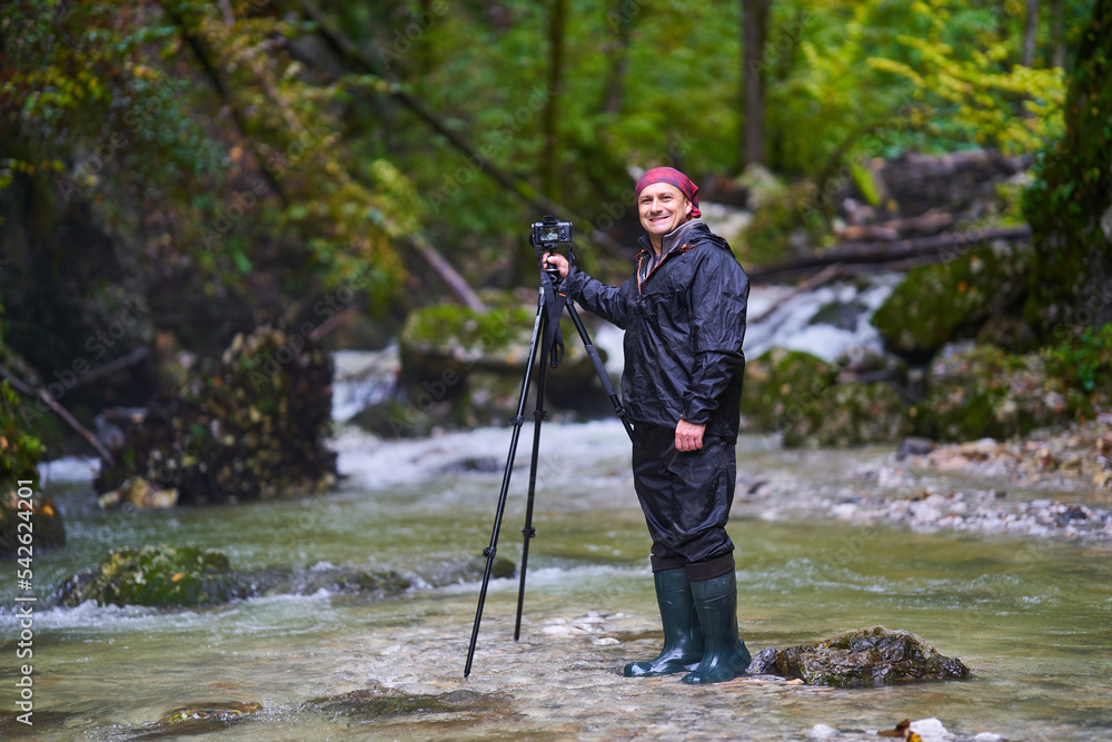 Nature photographer shooting landscapes in a canyon with a river