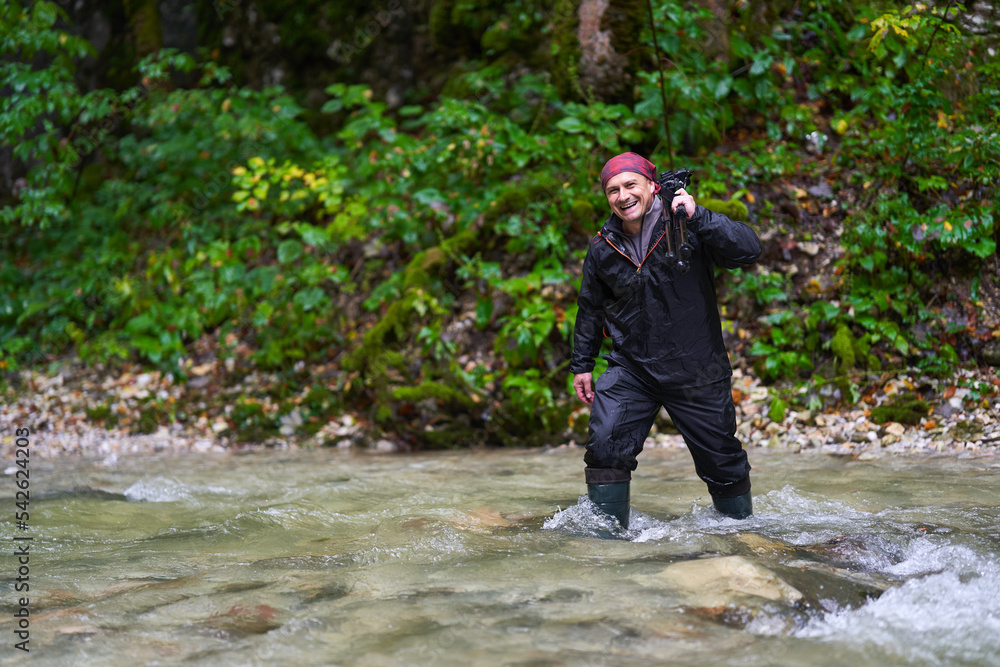 Nature photographer shooting landscapes in a canyon with a river Nature photographer shooting landscapes in a canyon with a river