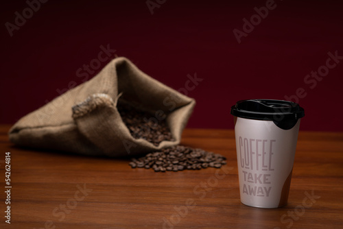 Coffee beans and disposable cup of coffee 