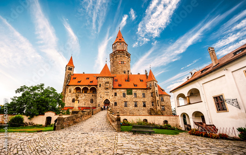 Bouzov castle. Fairytale castle in czech highland landscape. Castle with white church, high towers, red roofs, stone walls. Czech republic.