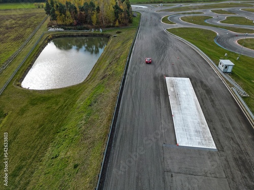 Obraz na płótnie car racing track and racing cars as seen from above from a drone. Fast, luxury cars. w salonie