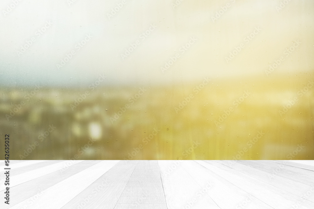 White Wood Floor with Blurred Window Glass with Raindrop and Scenery of Sunrise at the City Background.