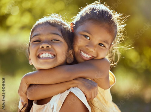 фотографія Girl, hug and love, sisters and happy in portrait together, young kids outdoor and family bonding in nature
