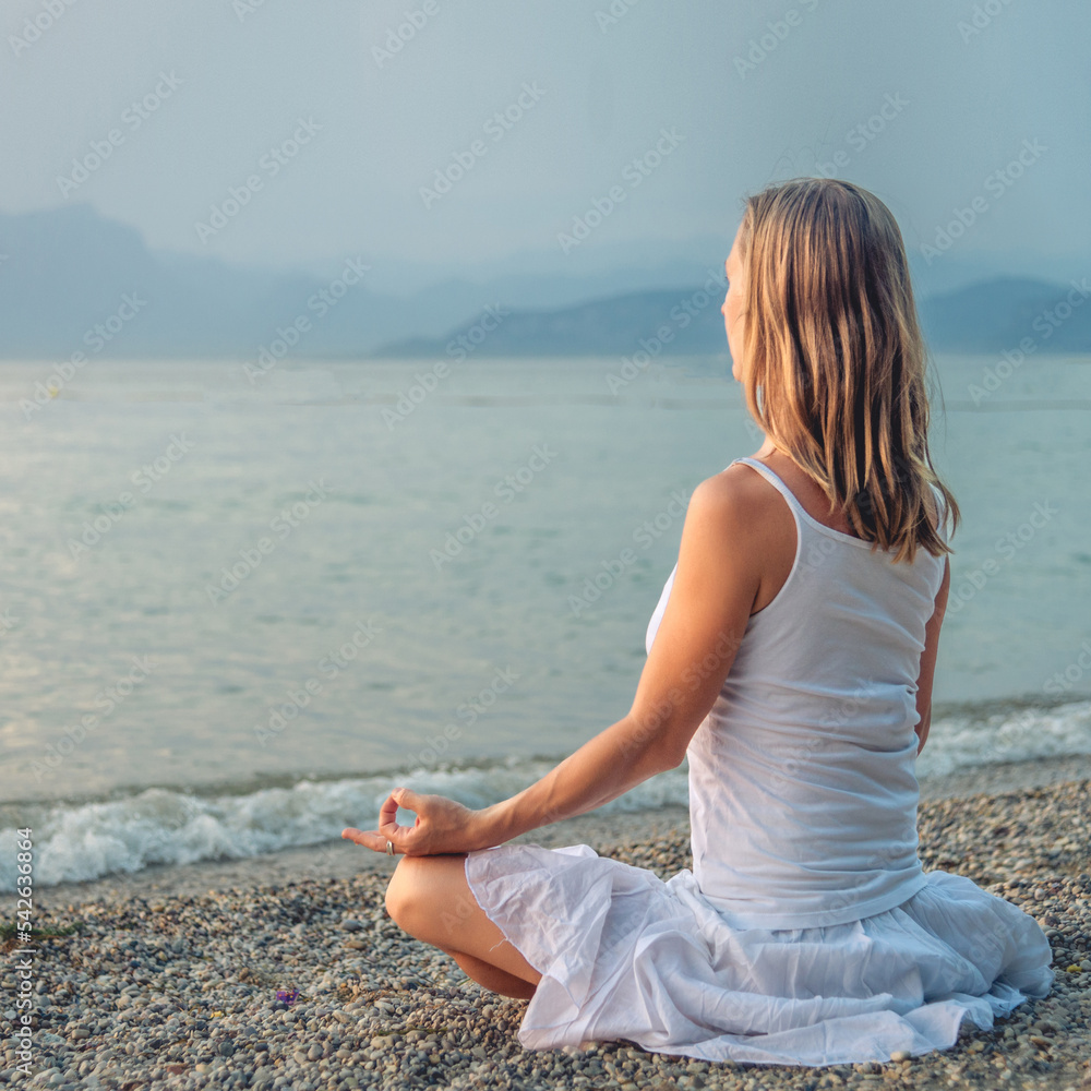 Woman meditating at the Garda Lake. Sunset. Woman meditating at the Garda Lake. Sunset.