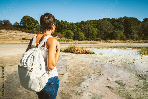 Young woman trekking to the Solfatara di Manziana (sulphurous area) in Italy. The woman is from behind and she is admiring the landscape. photo