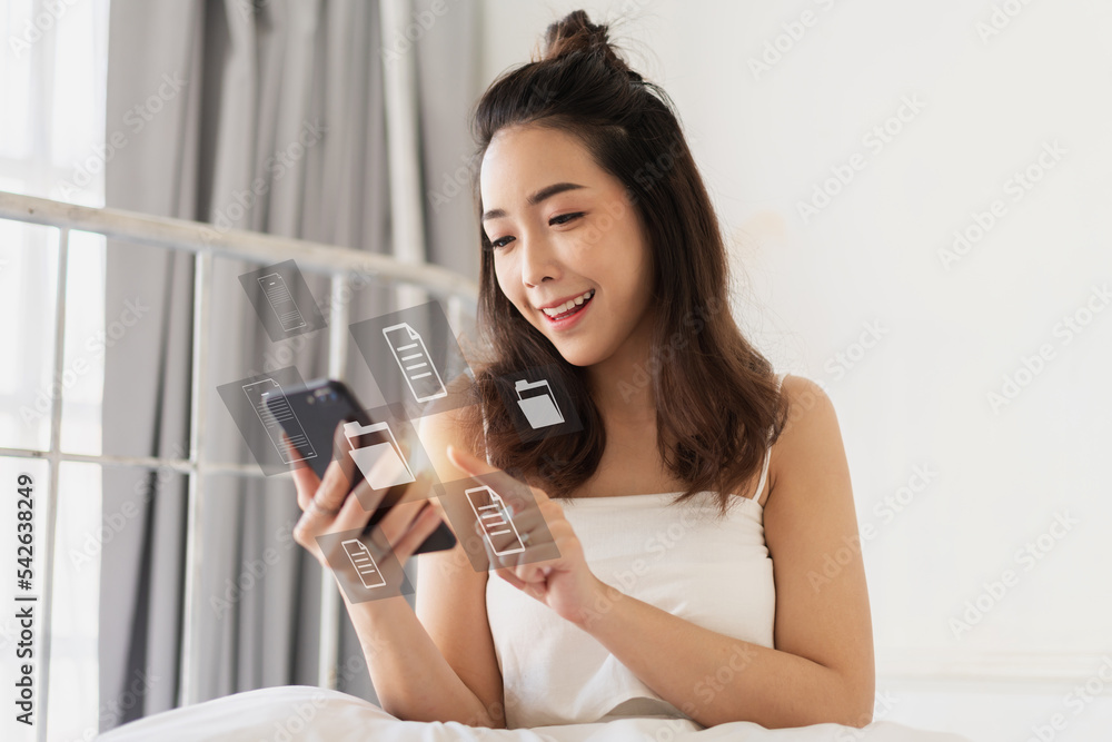 Portrait woman use digital technology online cloud document file management information system with smartphone.Young girl looking at phone screen with icon manage file at home Portrait woman use digital technology online cloud document file management information system with smartphone.Young girl looking at phone screen with icon manage file at home
