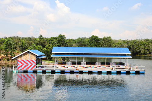 floating house, a place to eat that is above the lake with a blue and white sky