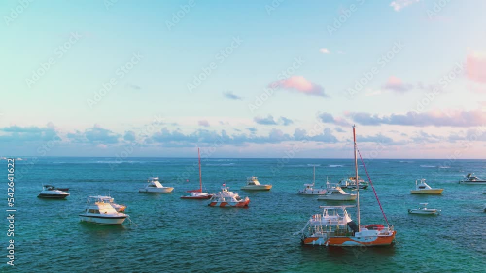 Sailing boats on the background of the sea sunset. Yachts on the waves. Summer sea sunset. Pink clouds in a turquoise sky. Evening seascape with boats. Sailing boats on the background of the sea sunset. Yachts on the waves. Summer sea sunset. Pink clouds in a turquoise sky. Evening seascape with boats.