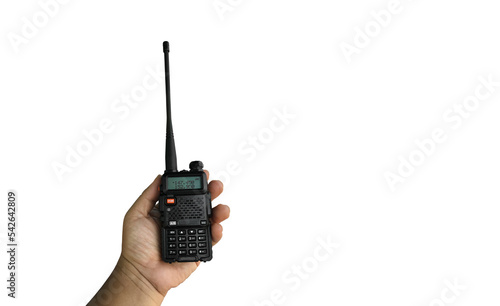 A portable radio transmitter holding in hand, blurred an outdoor building which is constructioning, soft and selective focus. photo